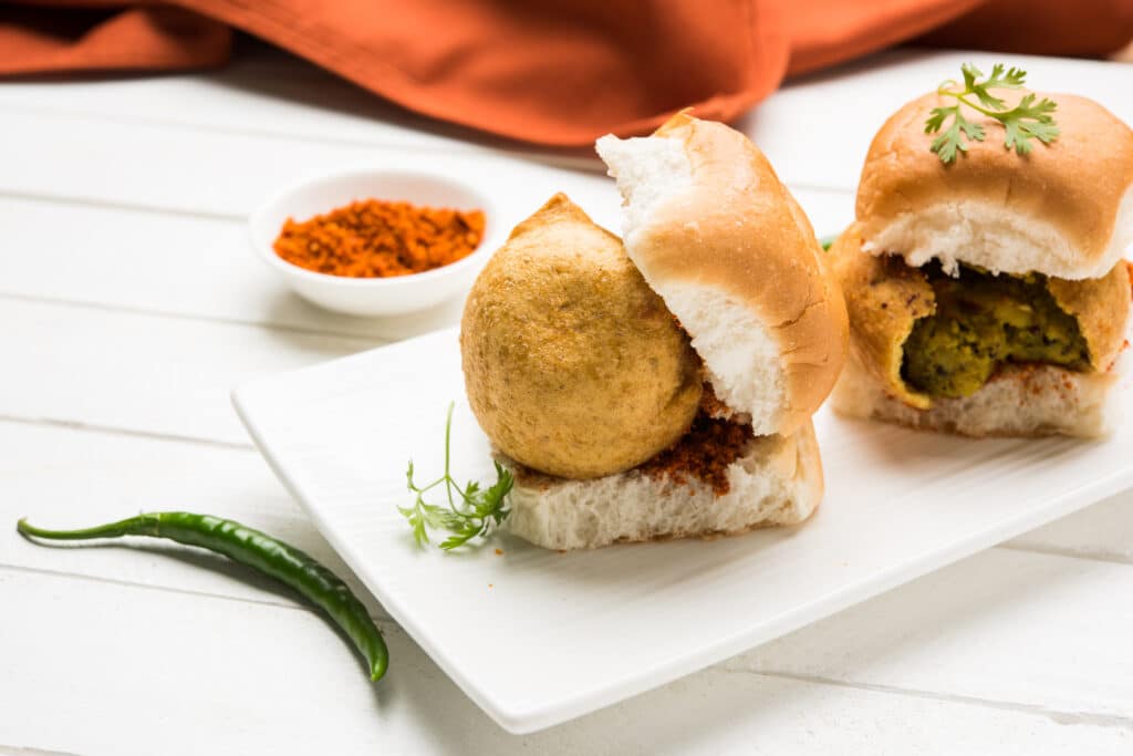 Fresh and crispy vadapav served with spicy chutney on a white plate, a popular Indian street food and top choice for vadapav in Melbourne.